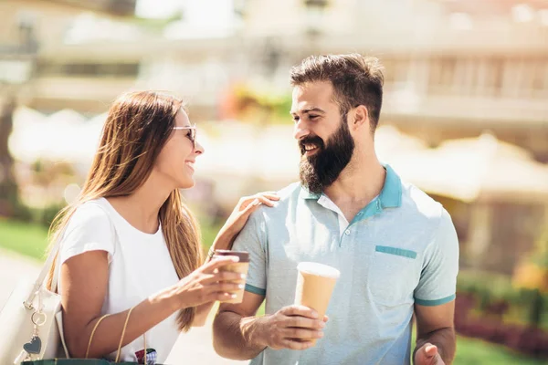 Pareja Joven Sonriente Mirándose Mientras Caminan Con Café Para Salir — Foto de Stock