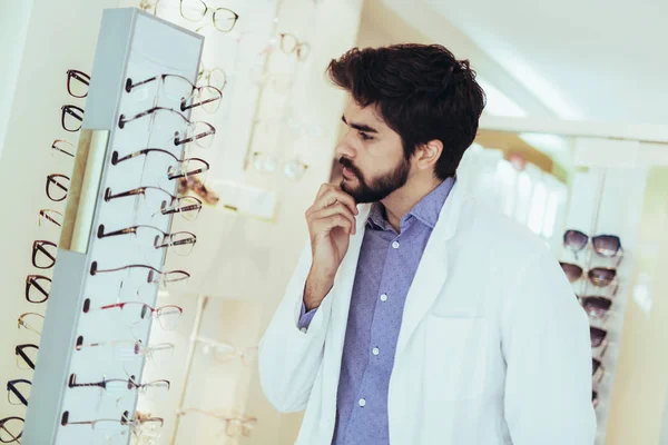 Man optician in coat at optics store