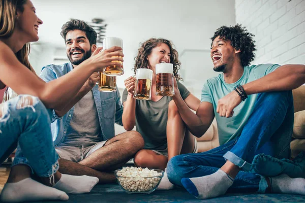 Patlamış mısır yeme ve içme bira bardağı evde, mutlu arkadaşlar eğlenmeye.