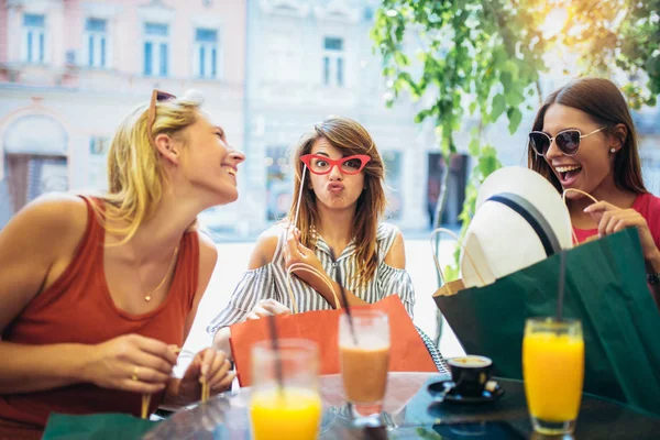 İçecekler içme ve eğlenmek kafede üç genç kadın