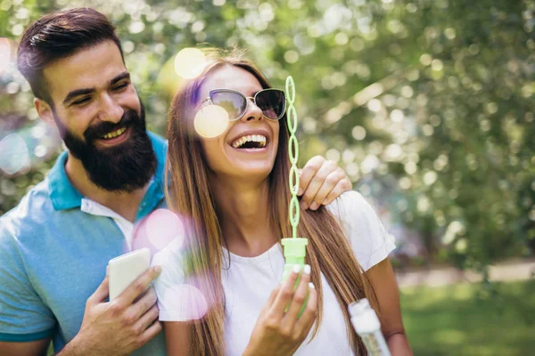 Charmiga Unga Par Som Sitter Bänken Parken Och Blåser Bubblor — Stockfoto