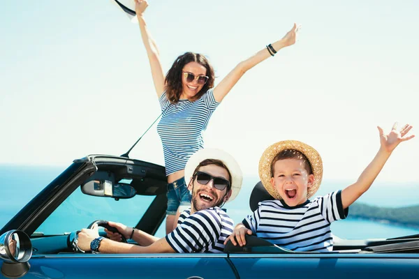 Happy family travel and having fun in cabriolet car near sea