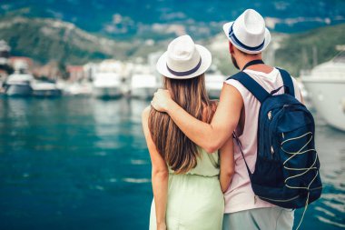 Rea r görünümü yolcuları deniz tatil Yatlar yakınındaki yürüme çift.