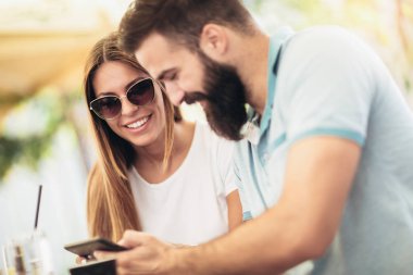 Randevularında kahve içen güzel bir çift online alışveriş için dijital tablet ve kredi kartı kullanıyor.