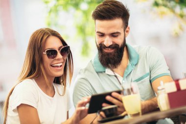 Randevularında kahve içen güzel bir çift online alışveriş için dijital tablet ve kredi kartı kullanıyor.