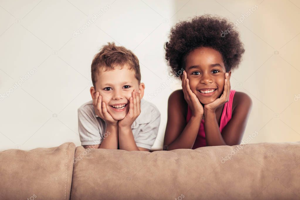 Caucasian boy and African American girl posing at home