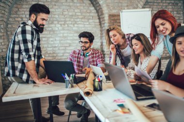 Masada otururken dizüstü kullanarak üniversite öğrencileri. Okul ödevi için Grup çalışması.