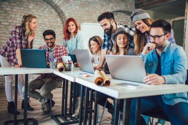 Masada otururken dizüstü kullanarak üniversite öğrencileri. Okul ödevi için Grup çalışması.