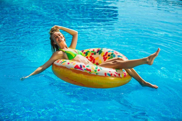 穿着比基尼的快乐女人在游泳池充气床垫上休息 — 图库照片