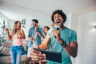 Evde, karaoke oynayan arkadaş grubu dostluk ve ev eğlence kavramı 