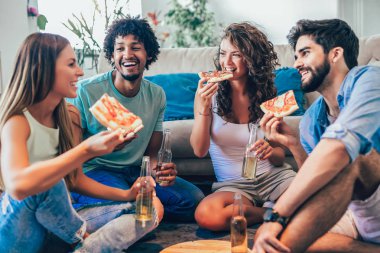 Grup Genç arkadaşlar ev partisi konsepti pizza ve içki bira evde, yemek 