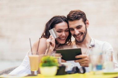 Tarihte kahve içer ve online alışveriş için kredi kartı ile dijital tablet ile güzel çift