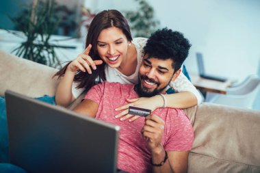 Laptop ve evde, kredi kartı tutan kadın kullanan adam online alışveriş kavramı