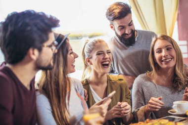 Pizzacı masada otururken tadını genç arkadaşlar 