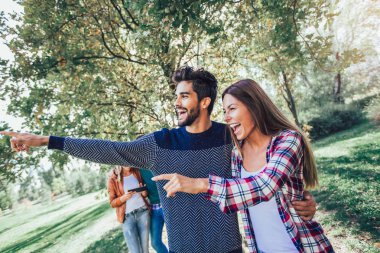 Bir grup genç mutlu insan parkta yürüyüş