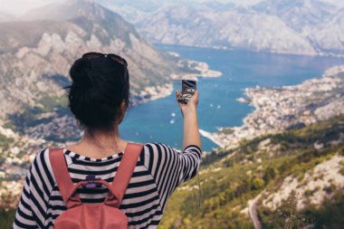 Turistik gezi, yaşam kavramı macera, Gezgin pusulasına sırt çantası ile arka plan dağ ve mavi deniz manzara ufuk üzerinde tutun. Kotor Körfezi Dağları Lovcen görünümünü.