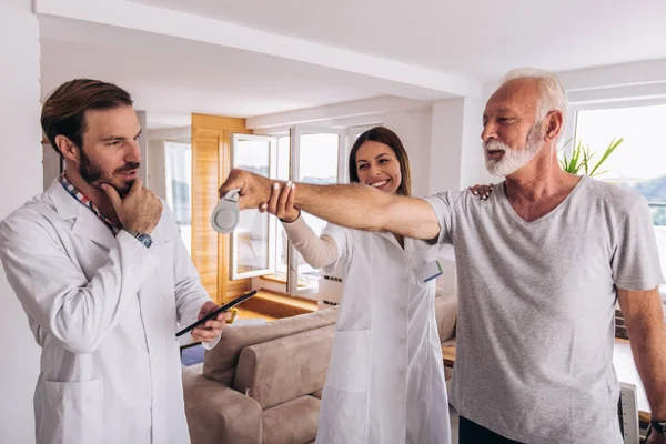 Man having chiropractic arm adjustment. Physiotherapy, sport injury rehabilitation. Senior man exercises in center for chiropractic.