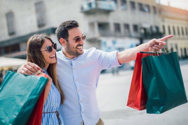 Güzel genç bir çift alışveriş yapıyor, şehirde eğleniyor.