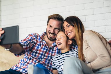 Mutlu aile dijital tablet alarak selfie evde kullanma ve having fun.