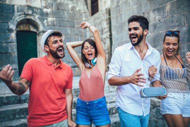 Şehirde gezi genç mutlu turistler. Onlar eğlenceli yaşıyorsanız müzik
