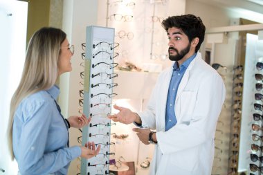 Bir optik merkezinde bir müşteri için bir görsel muayene yaparken göz doktoru.