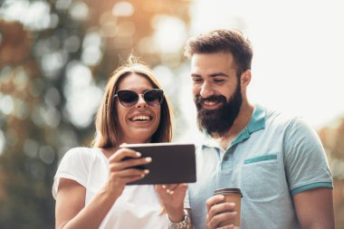 Genç çekici çift konuşmak ve dijital tablet vasıl arıyorsunuz.