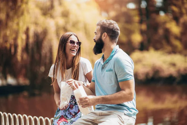 Güzel güneşli gün patlamış mısır yeme parkta genç çift