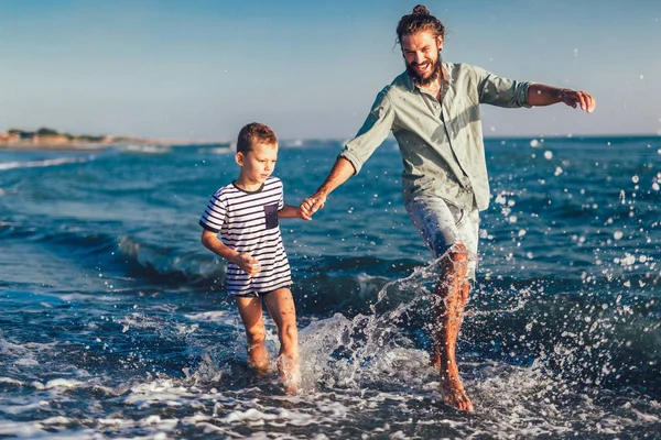 快乐的父亲和儿子 男人和男孩的孩子 在沙滩上奔跑 在阳光明媚的沙滩上玩耍 — 图库照片