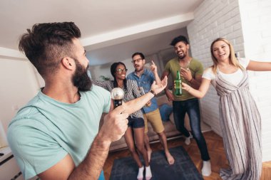 Evde karaoke yapan bir grup arkadaş. Arkadaşlık kavramı, ev eğlencesi ve insanlar