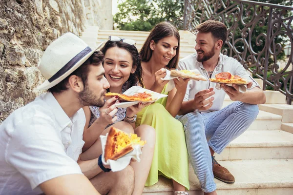 Happy people eating fast food in city while travelling