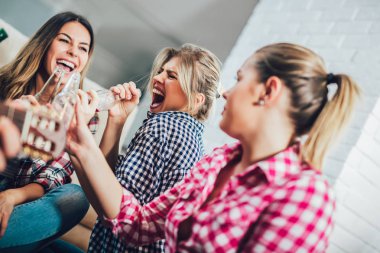 Bir grup mutlu genç arkadaş evde bira içip eğleniyorlar.
