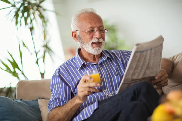 Старший Чоловік Вдома Читає Газету Тримає Свіжий Сік — стокове фото