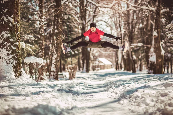Молодий Бігун Спортивному Одязі Стрибає Снігу Покритій Зимовою Дорогою Біля — стокове фото