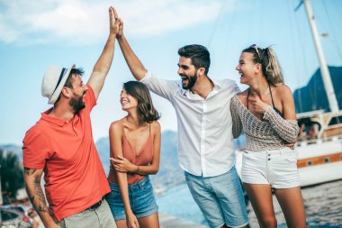 Bir turistik deniz tatil tekne ile liman tarafından arka planda yürüyen arkadaşlar