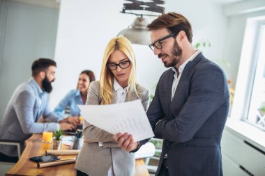 Meslektaşım arka planda iken iki genç iş adamları portresi
