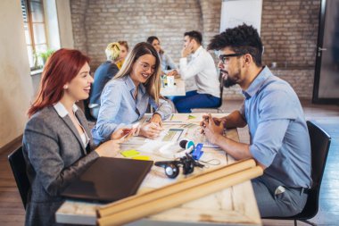  Grup genç iş adamları içinde smart casual giyim birlikte yaratıcı ofisinde çalışan
