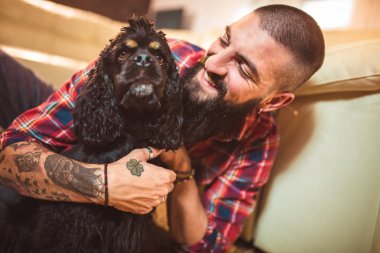 Evde sevimli köpeği olan yakışıklı bir adam.