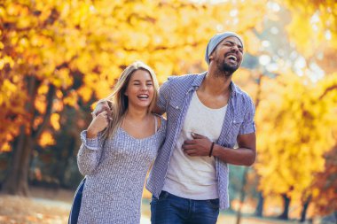 Sonbahar Park'ta yürüyordunuz genç karışık çift