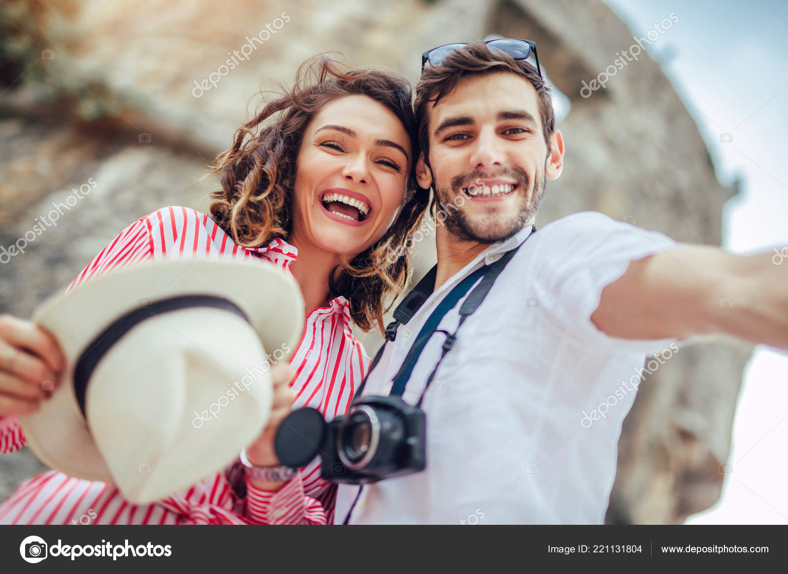 Young couple taking selfie with smartphone in front of blue brick wall - a  Royalty Free Stock Photo from Photocase