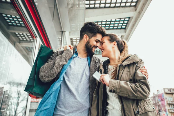 Beautiful couple shopping with a credit card in the city