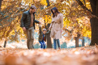 Genç aile Sonbahar Park oğlu ile eğleniyor.