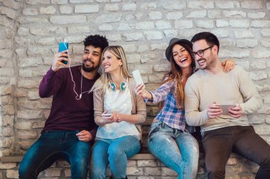 Çeşitlilik öğrencilerin arkadaş dijital cihazlar genel kavram istimal, tuğla duvar arka plan.