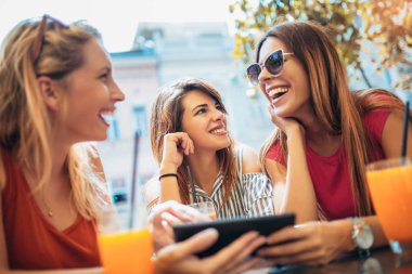 Üç güzel arkadaş bir kafe kullanarak tablet pc ve having fun