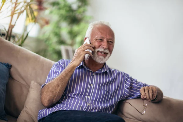 Starší Muž Chatování Mobilním Telefonu Při Odpočinku Pohovce Obývacím Pokoji — Stock fotografie