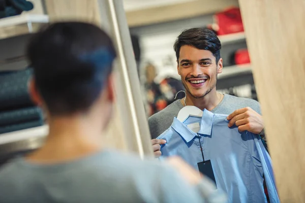 Young Man Choosing Shirt Looking Mirror Mall Clothing Store — Stock Photo, Image