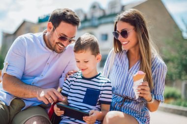 Gülümseyen veliler ve tablet pc açık olan küçük çocuk