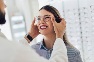 Bir optik merkezinde bir müşteri için bir görsel muayene yaparken göz doktoru.