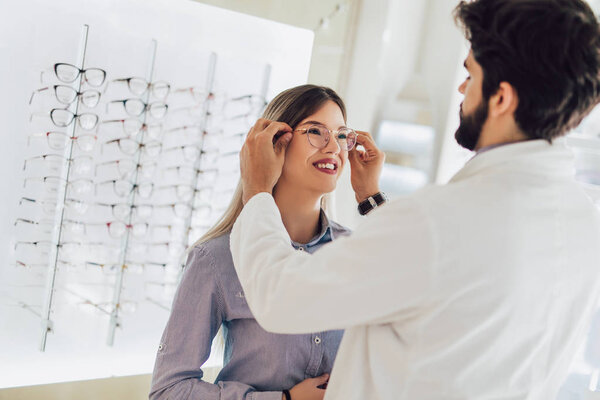 Ophthalmologist doing a visual examination for a customer at an optical center.