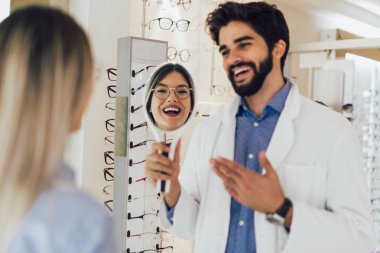 Bir optik merkezinde bir müşteri için bir görsel muayene yaparken göz doktoru.