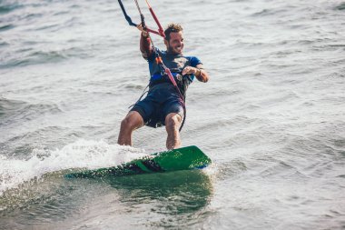 Profesyonel kiter zor hüner güzel bir arka plan üzerinde yapar. Kitesurfing Kiteboarding eylem fotoğraflar adam dalgalar arasında hızlı bir şekilde gider